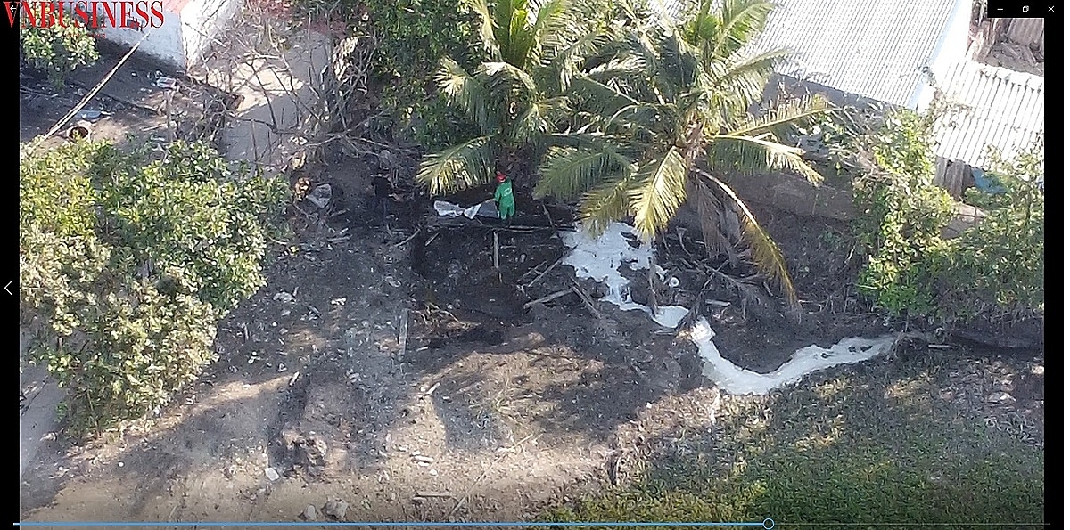 Chất thải (màu trắng đục) theo hệ thống cống ngầm chảy ra phía bờ sông. Sau khi xả, công nhân công ty che chắn hệ thống ống nối bằng cách phủ cành cây, vỏ bao lên (ảnh cắt từ video).