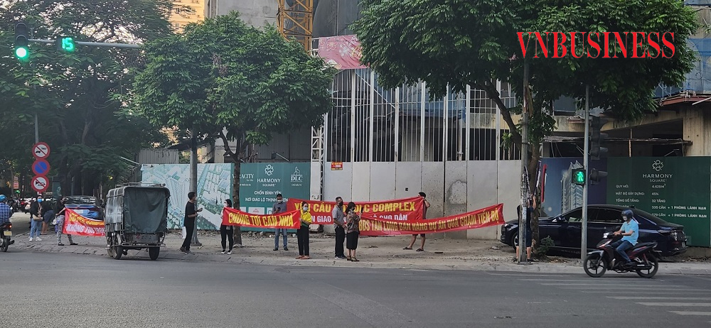 Nhiều khách hàng căng băng rôn yêu cầu chủ đầu tư bàn giao căn hộ đúng tiến độ.