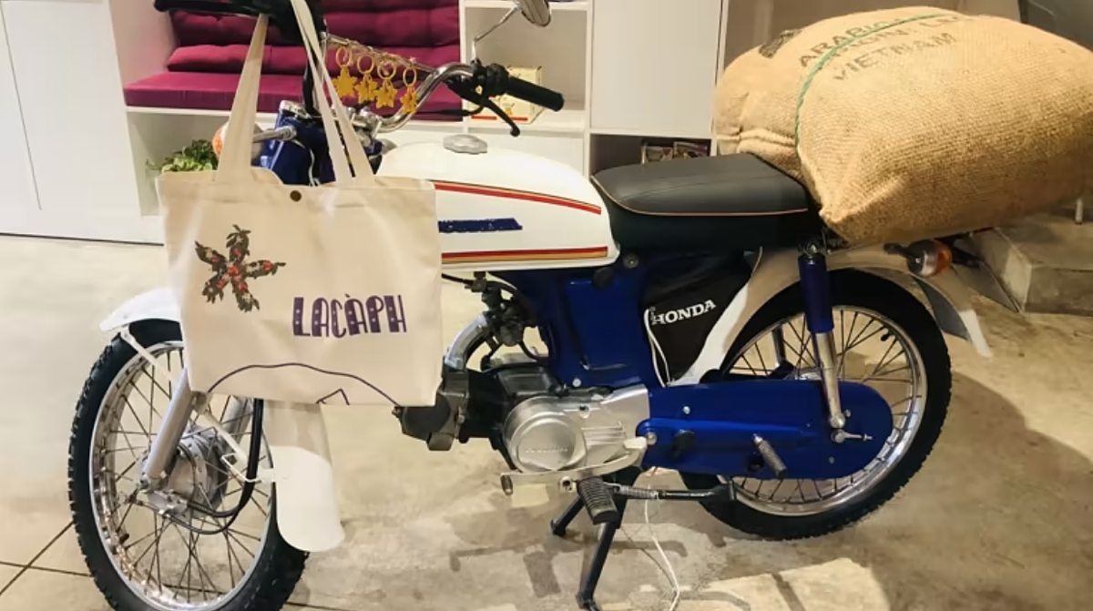 Lacaph Việt Nam trang trí quán cà phê bằng một chiếc xe máy mang tính biểu tượng chở một túi đậu. (Ảnh: Liên Hoàng)