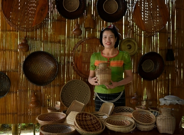 Chị Lô Thị Hoa, giám đốc HTX Nông nghiệp và Du lịch cộng đồng xã Yên Khê bên sản phẩm mây tre đan truyền thống đồng bào Thái.