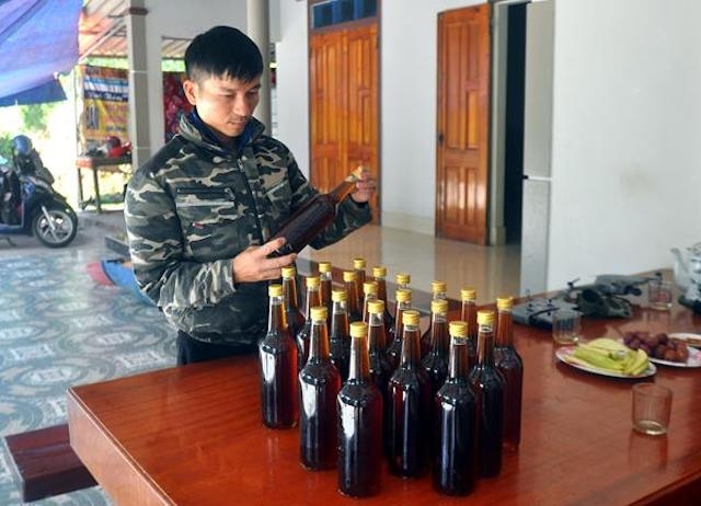 Anh Bạch Văn Thắng đang kiểm tra mật ong trước khi xuất ra thị trường tiêu thụ.