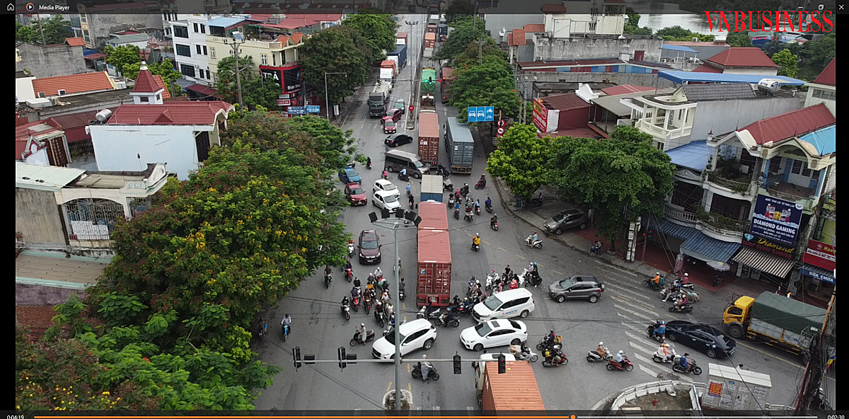 Xe máy, ô tô con thi nhau luồn lách qua hàng container.