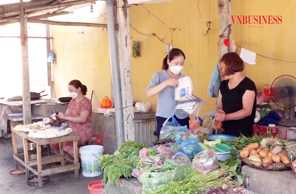 Chị Nguyễn Thị Mai &lpar;giữa&rpar; tuyên truyền chính sách BHXH tự nguyện cho các tiểu thương ở chợ.