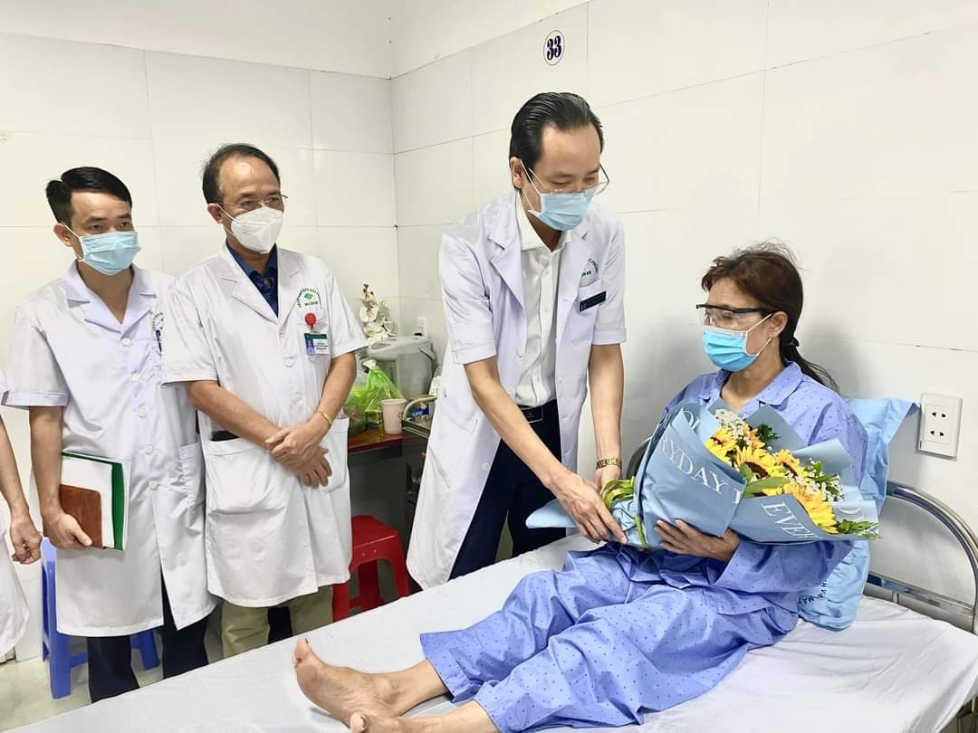 Giám đốc bệnh viện Mắt Hải Phòng, ông Nguyễn Đức Quân tặng hoa động viên người bệnh sau khi nhận ghép giác mạc thành công &lpar;ảnh BV cung cấp&rpar;.