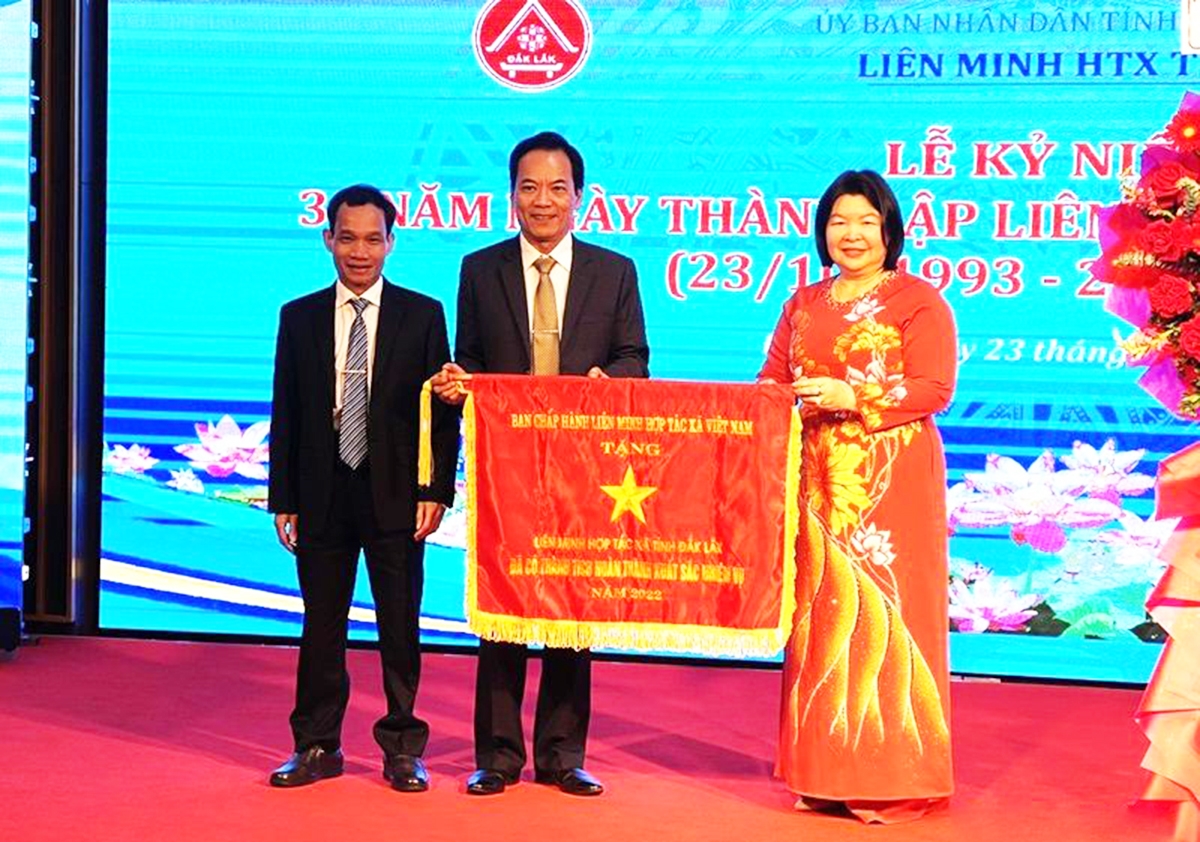 Chủ tịch Liên minh HTX Việt Nam Cao Xuân Thu Vân trao cờ thi đua xuất sắc năm 2022 cho Liên minh HTX tỉnh Đắk Lắk.