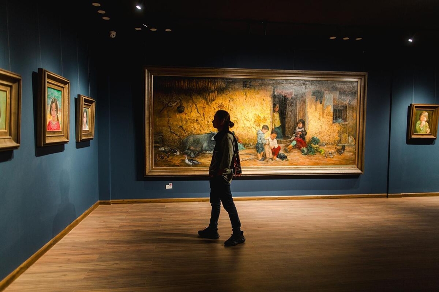 Họa sĩ Bùi Văn Tuất trong không gian triển lãm tranh của mình.