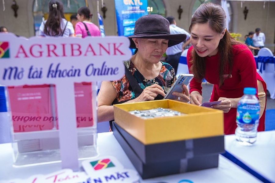 Cán bộ Agribank Chi nhánh Hùng Vương hỗ trợ khách hàng tìm hiểu sản phẩm dịch vụ của Agribank tại gian hàng.