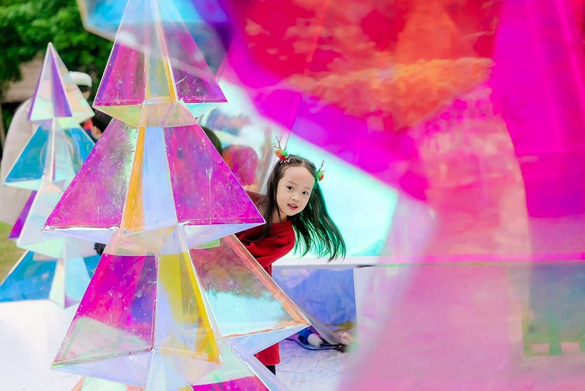 Các em bé thích thú với cây thông pha lê đổi màu.