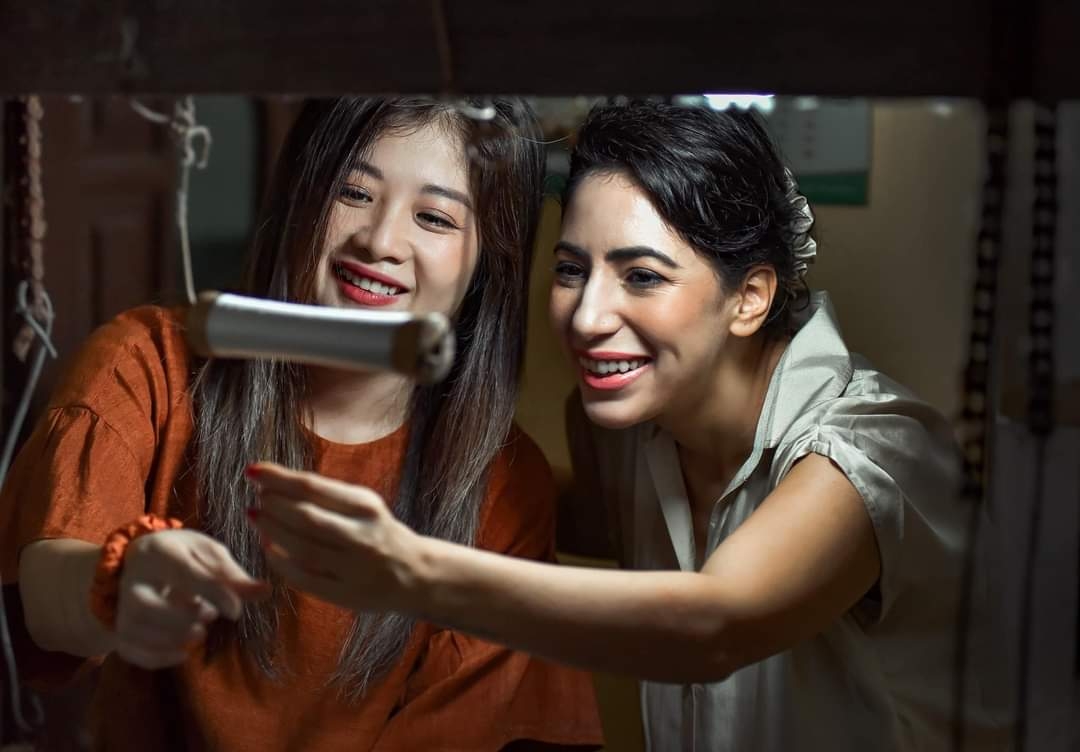 Chị Lương Thanh Hạnh, Giám đốc HTX Đũi Nam Cao &lpar;bên trái&rpar; đang giới thiệu với du khách nước ngoài về quá trình sản xuất tơ lụa.