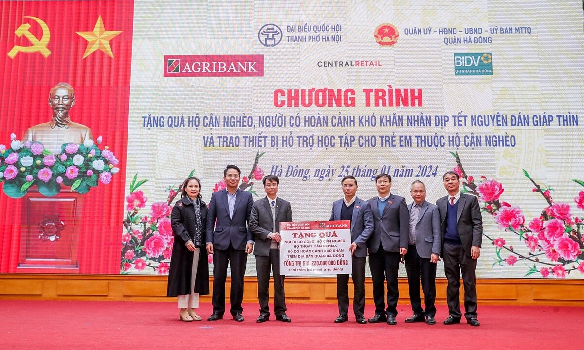Đồng chí Phạm Đức Ấn - Ủy viên Ban Thường vụ Đảng bộ Khối Doanh nghiệp Trung ương, Bí thư Đảng ủy, Chủ tịch Hội đồng thành viên Agribank trao tặng quà của Agribank hỗ trợ hộ cận nghèo, đối tượng chính sách quận Hà Đông &lpar;Hà Nội&rpar; nhân dịp Tết Nguyên đán Giáp Thìn.