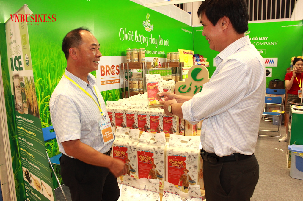 Gạo chất lượng cao của Việt Nam được đối tác thu mua của Trung Quốc &lpar;đứng bên trái&rpar; rất quan tâm và đặt nhiều đơn hàng.