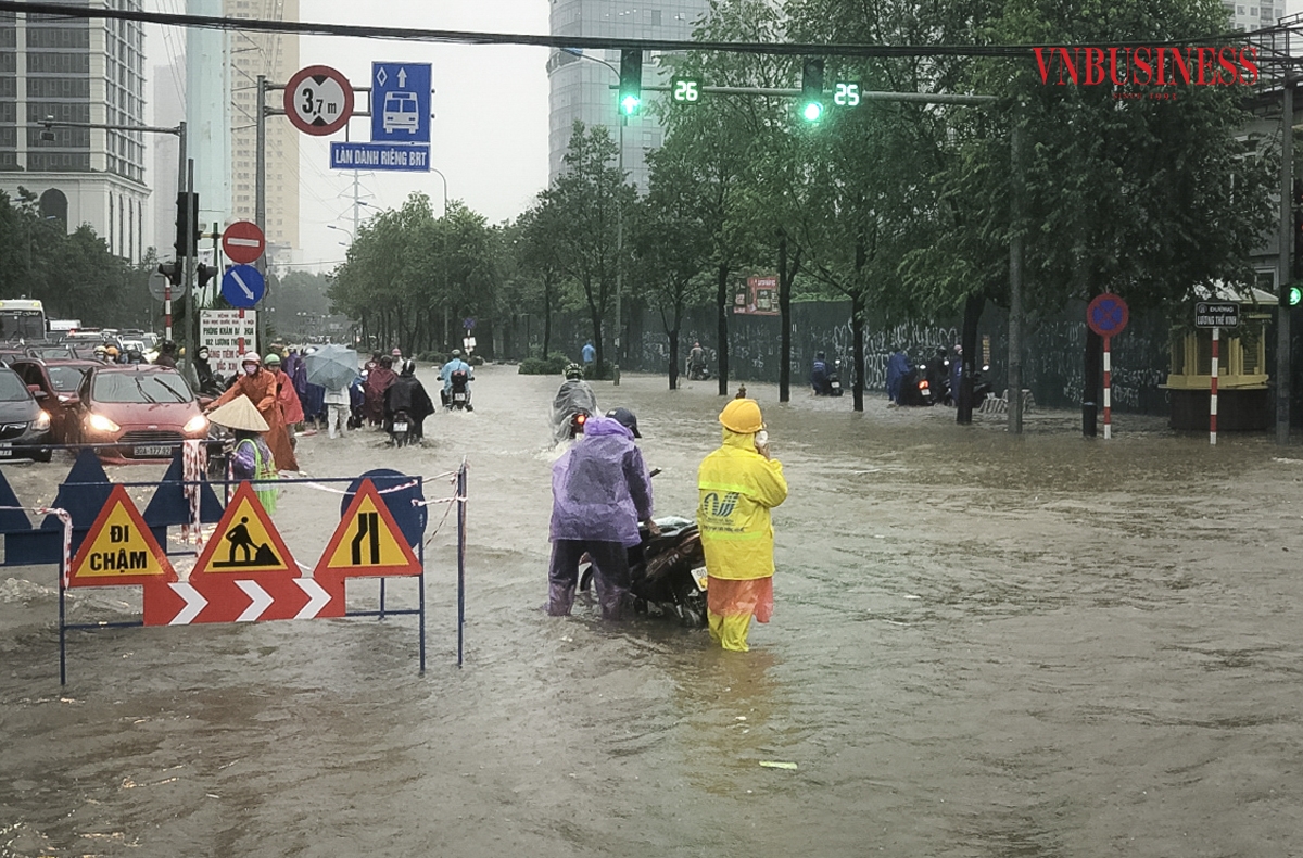 Đơn vị chức năng bố trí nhân lực có mặt từ sớm để mở nắp cống tiêu thoát nước và điều tiết giao thông qua các khu vực ngập úng.