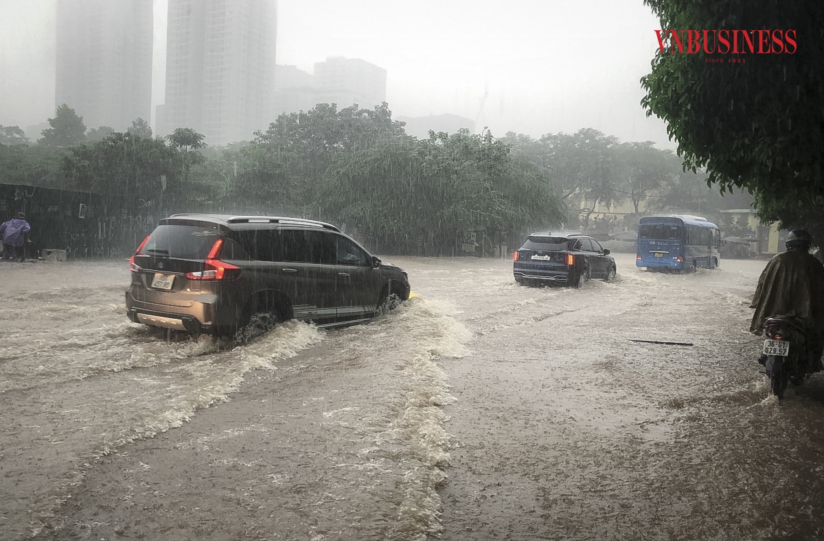 Đến 8h30, trời vẫn đổ mưa nặng hạt, nhiều người dân chật vật đến nơi làm việc.