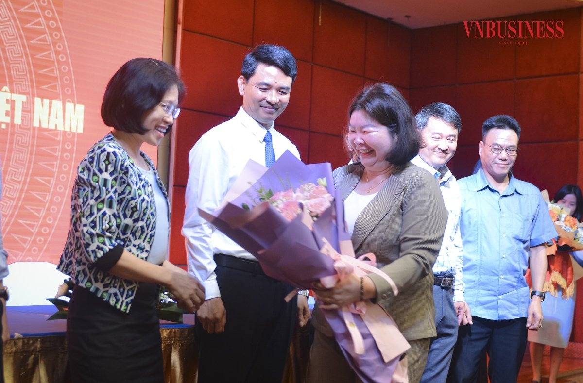 Bà Nguyễn Thị Hoài Linh &lpar;ngoài cùng bên trái&rpar; và ông Đinh Hồng Thái &lpar;thứ hai từ bên trái sang&rpar; nhận hoa chúc mừng của Chủ tịch Liên minh HTX Việt Nam Cao Xuân Thu Vân.