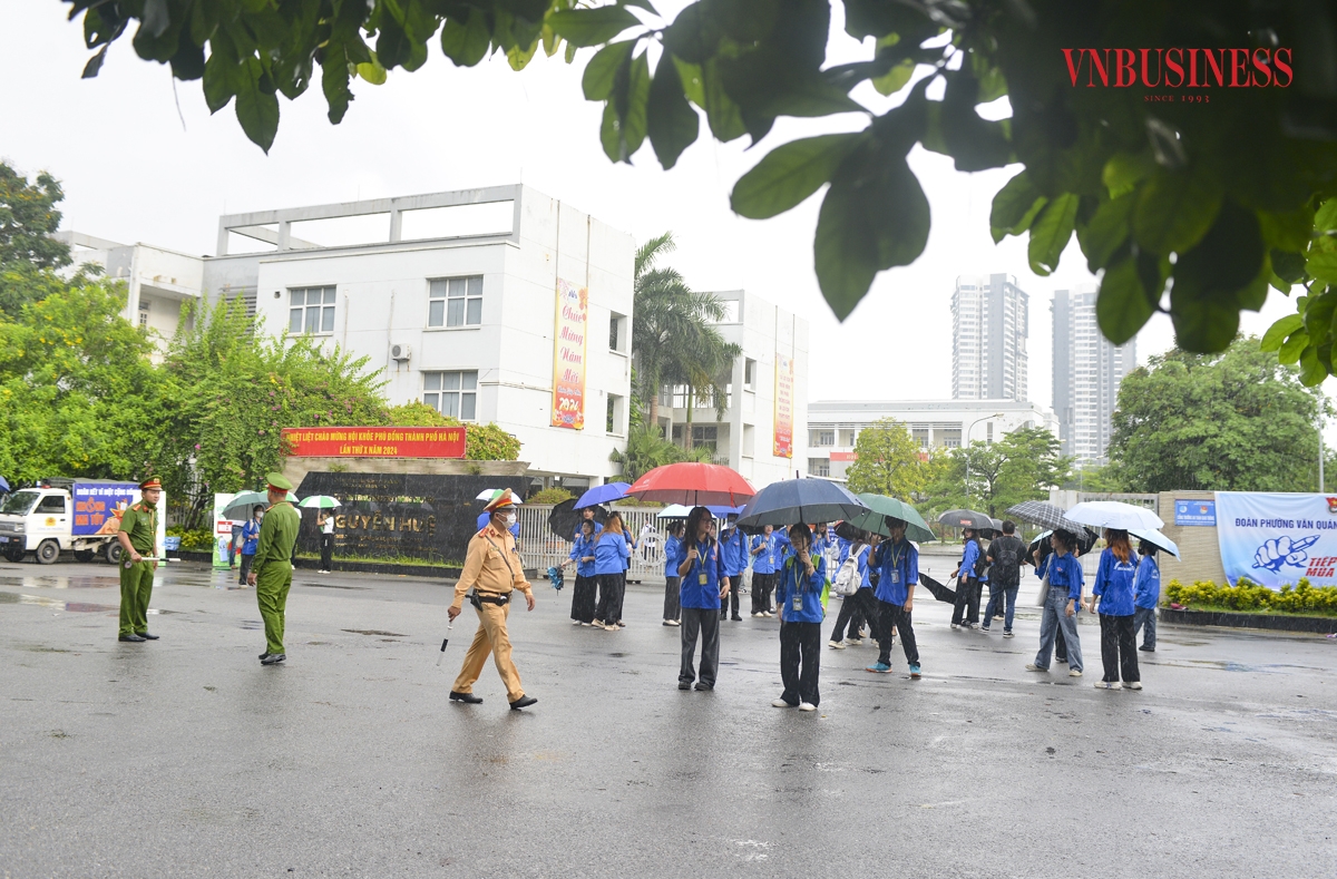 Ghi nhận tại điểm thi trường THPT chuyên Nguyễn Huệ &lpar;quận Hà Đông, Hà Nội&rpar;, cơn mưa nặng hạt ngay trước thời điểm bắt đầu bài thi môn ngữ văn, nhưng lực lượng chức năng và thanh niên tình nguyện đã có mặt từ rất sớm để triển khai phương án phân luồng giao thông, hướng dẫn thí sinh vào thi thuận lợi, đảm bảo tránh ùn tắc giao thông, an ninh trật tự.