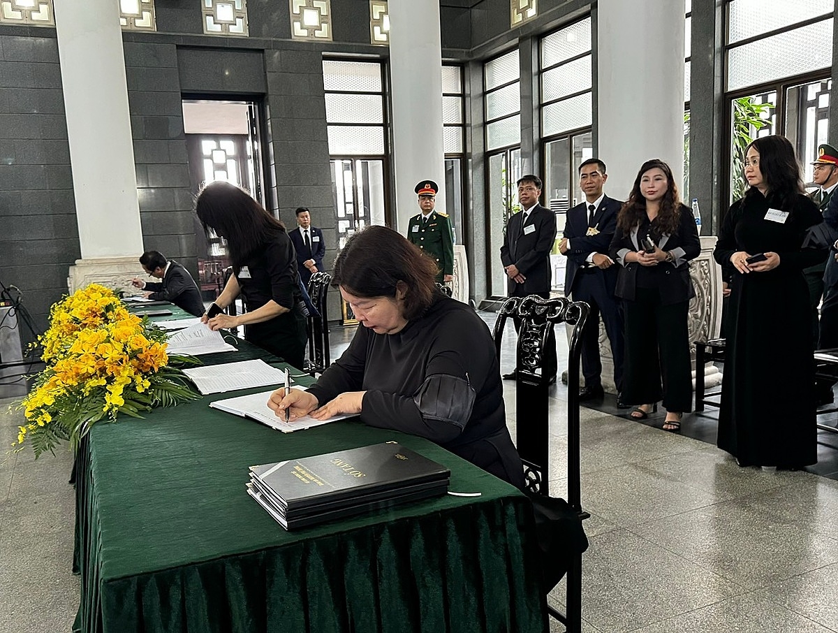 Đồng chí Cao Xuân Thu Vân, Bí thư Đảng Đoàn, Chủ tịch Liên minh HTX Việt Nam xúc động ghi sổ tang trong tang lễ Tổng Bí thư Nguyễn Phú Trọng. Ảnh VnBusiness