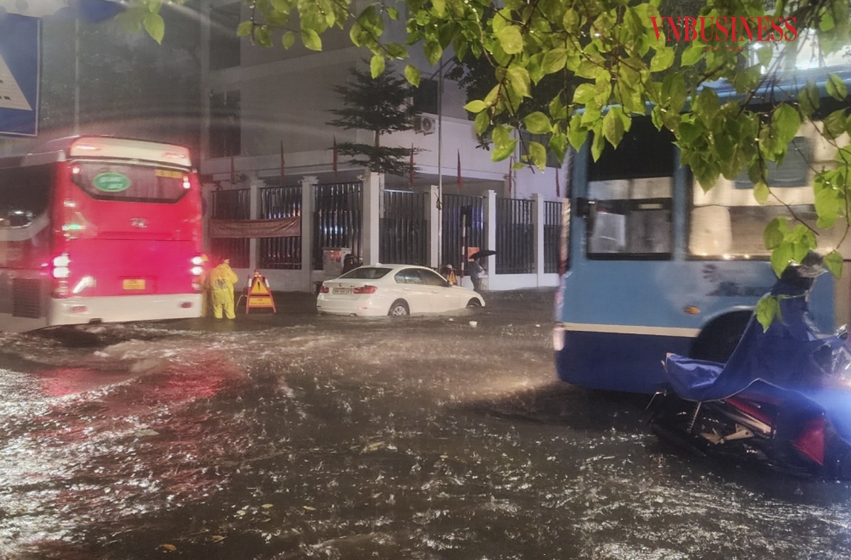 Nước ngập sâu, các phương tiện qua tuyến đường Trần Quốc Toản &lpar;quận Hoàn Kiếm&rpar; phải di chuyển chậm rãi mới thoát qua được.