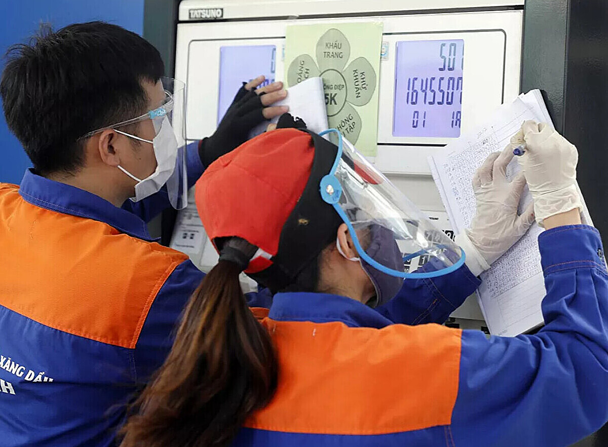 Nhân viên cửa hàng xăng dầu điều chỉnh giá bán.