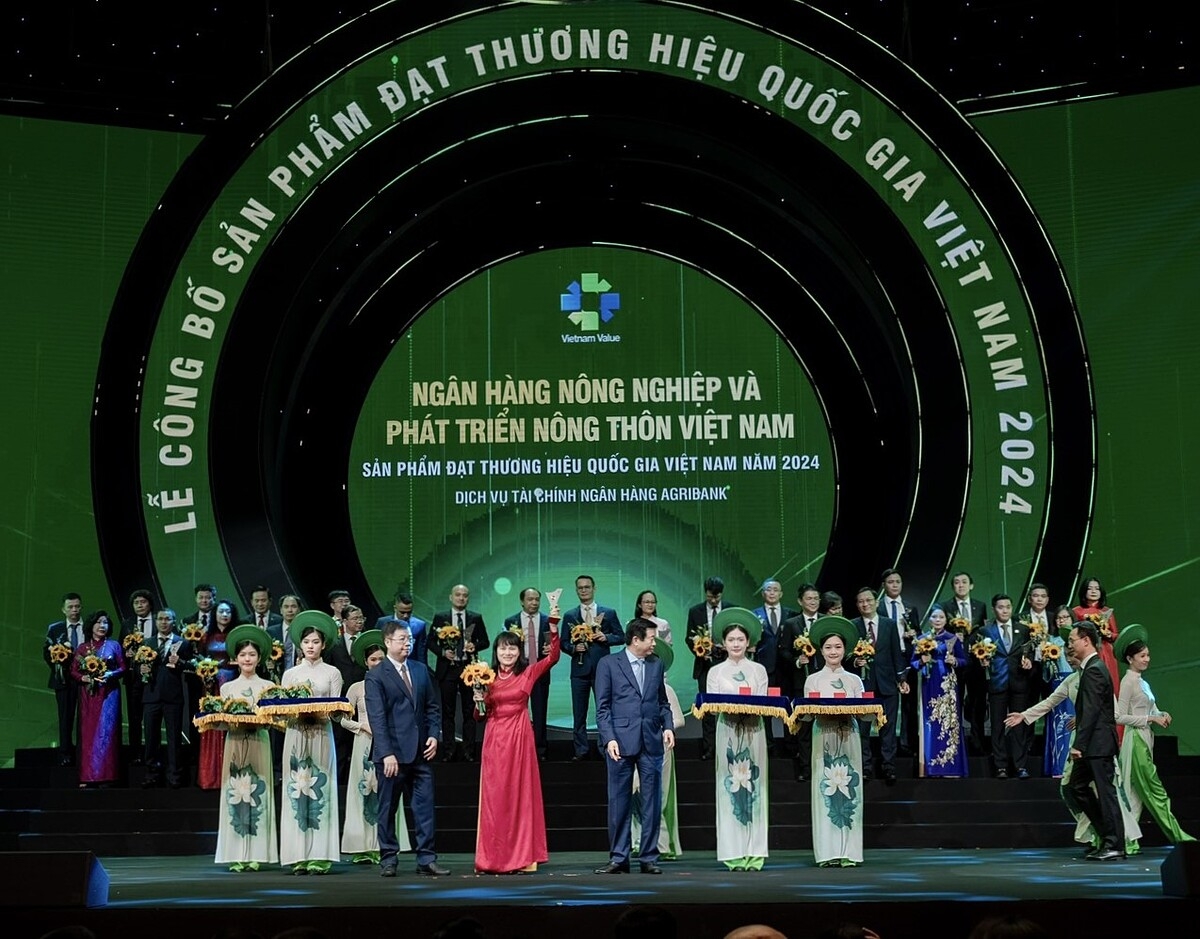 Đại diện Agribank, bà Phùng Thị Bình - Phó Tổng Giám đốc Agribank nhận hoa và biểu trưng của Chương trình.