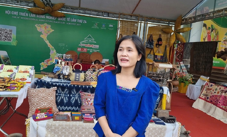 Chị Sầm Thị Tình, Hợp tác xã &lpar;HTX&rpar; làng nghề thổ cẩm Hoa Tiến bên những sản phẩm thổ cẩm được sản xuất bởi người dân địa phương.