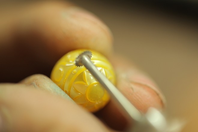 Kỹ thuật viên của Công ty Hoàng Gia đang kiểm tra viên ngọc trai có hoa văn trống đồng.