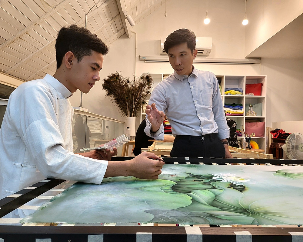 Nghệ nhân Trung Đinh truyền dạy vẽ lụa cho học viên của mình.