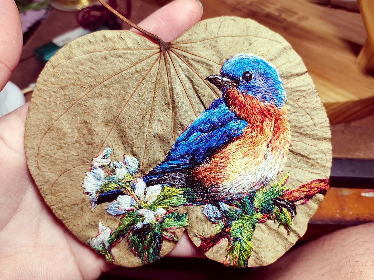 Nhật Khiêm thêu chim trên lá.