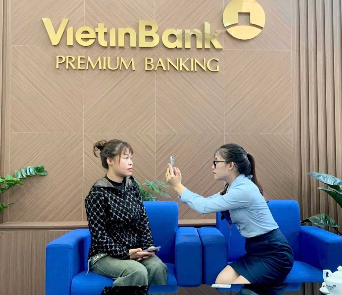 Nhân viên VietinBank hỗ trợ khách hàng thực hiện sinh trắc học.