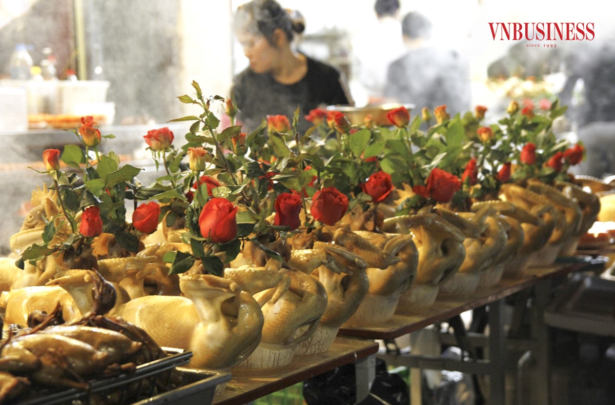 Gà luộc xong được cắt tỉa, tạo dáng cánh tiên rồi cắm thêm hoa hồng và bày bàn cho khách lựa chọn.