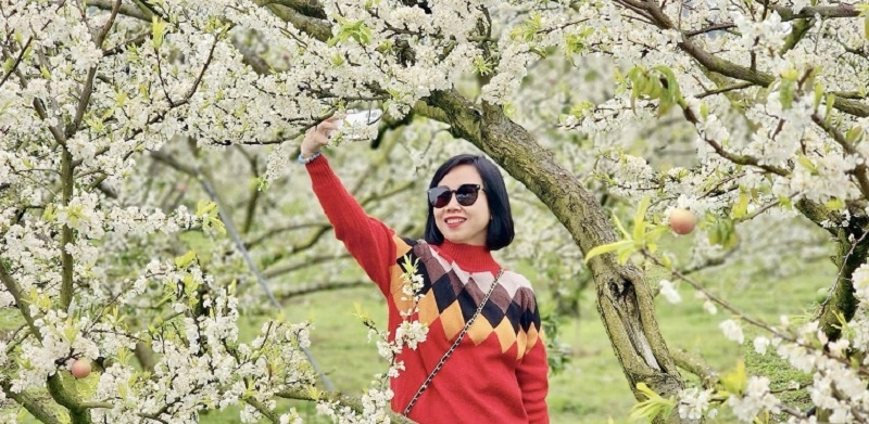 Du khách thích thú lưu lại những hình ảnh đẹp bên vườn mận trắng.