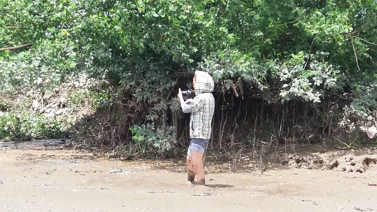 Phóng viên không ngần ngại lội dọc bờ sông để có những bức ảnh đẹp.