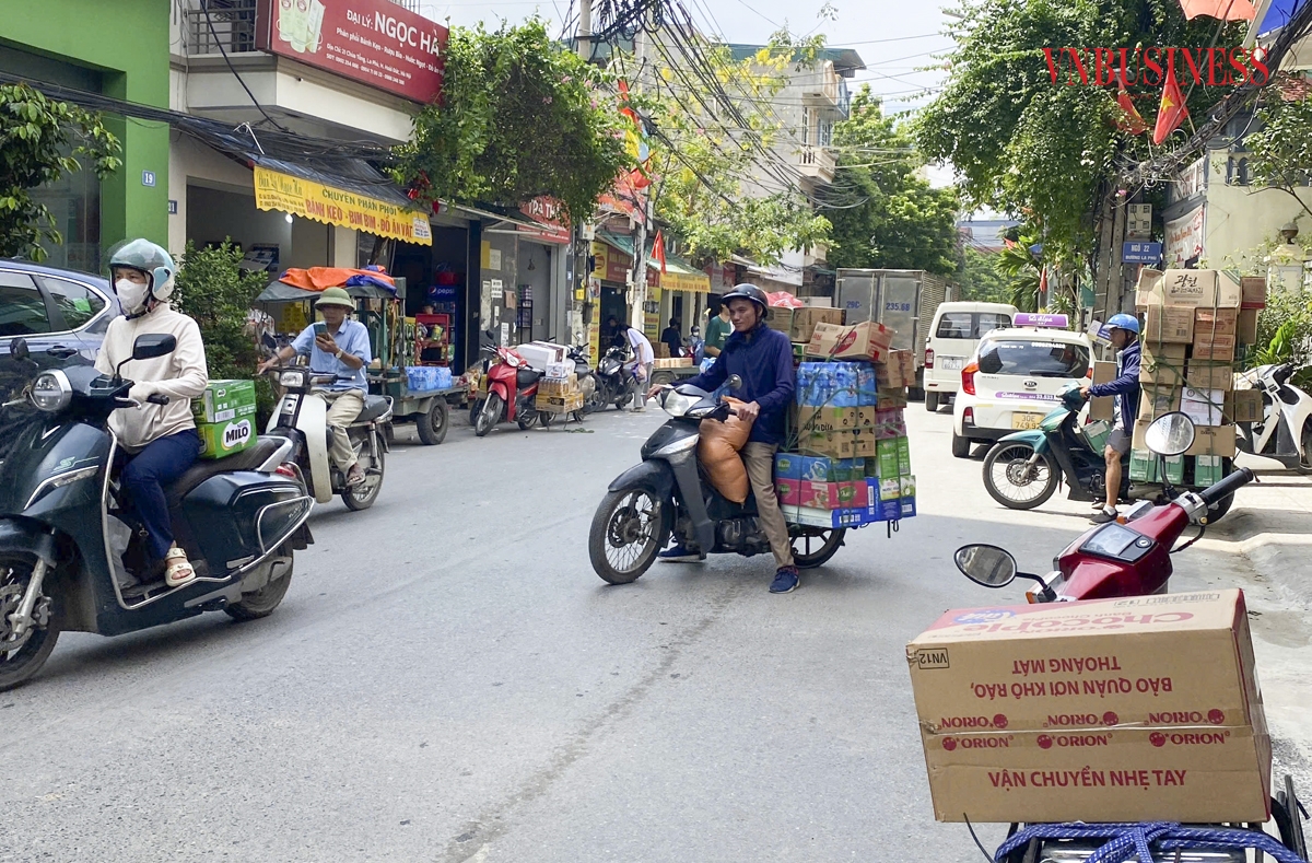 Dọc tuyến phố Minh Khai &lpar;La Phù&rpar; đều là điểm tập kết, luân chuyển hàng hóa nên có rất nhiều xe tải đậu chờ lên hàng. Từ các ngõ ngách xương cá, xe ba bánh ùn ùn vào ra, liên tục ách tắc.
