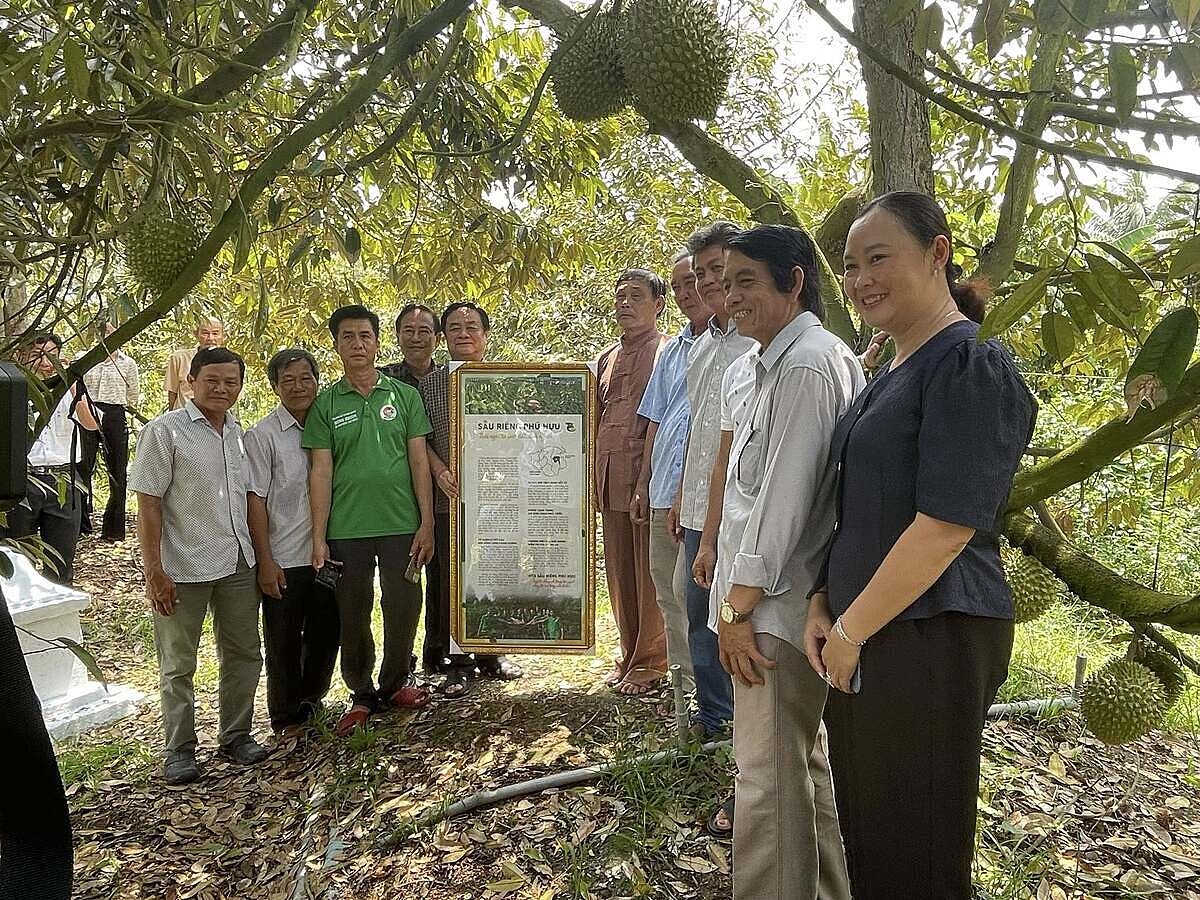 Phó Chủ tịch Quốc hội Lê Minh Hoan &lpar;thứ 5 từ trái sang&rpar; chụp ảnh lưu niệm cùng bà con nhà vườn HTX Sầu riêng Phú Hựu.
