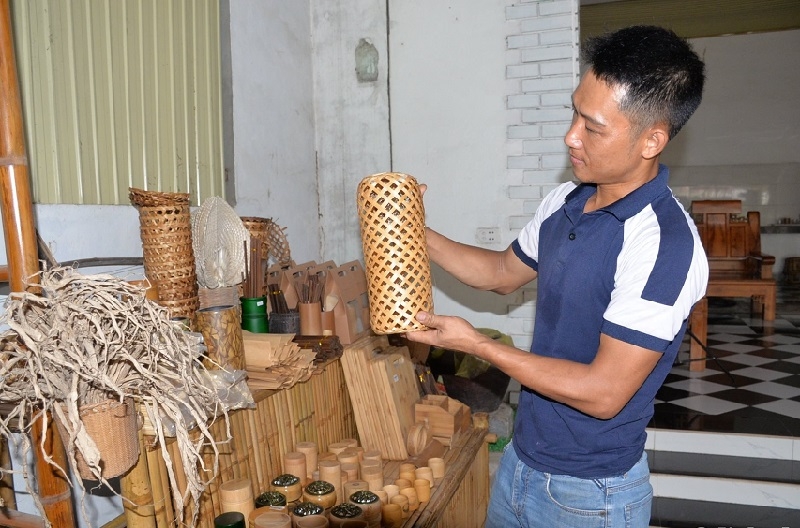 Anh Thái Đăng Tiến - Giám đốc HTX tre Trà Lân, xã Châu Khê, huyện Con Cuông bên những sản phẩm mỹ nghệ làm từ tre.