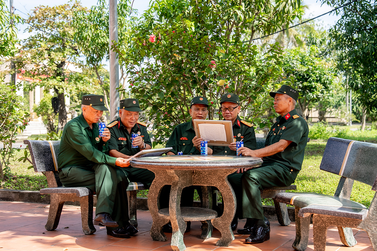 Các bác cựu chiến binh chăm chú đọc những dòng chữ nhỏ, được các em gửi kèm trong mỗi bức tranh &lpar;Ảnh: Duy Cường&rpar;.