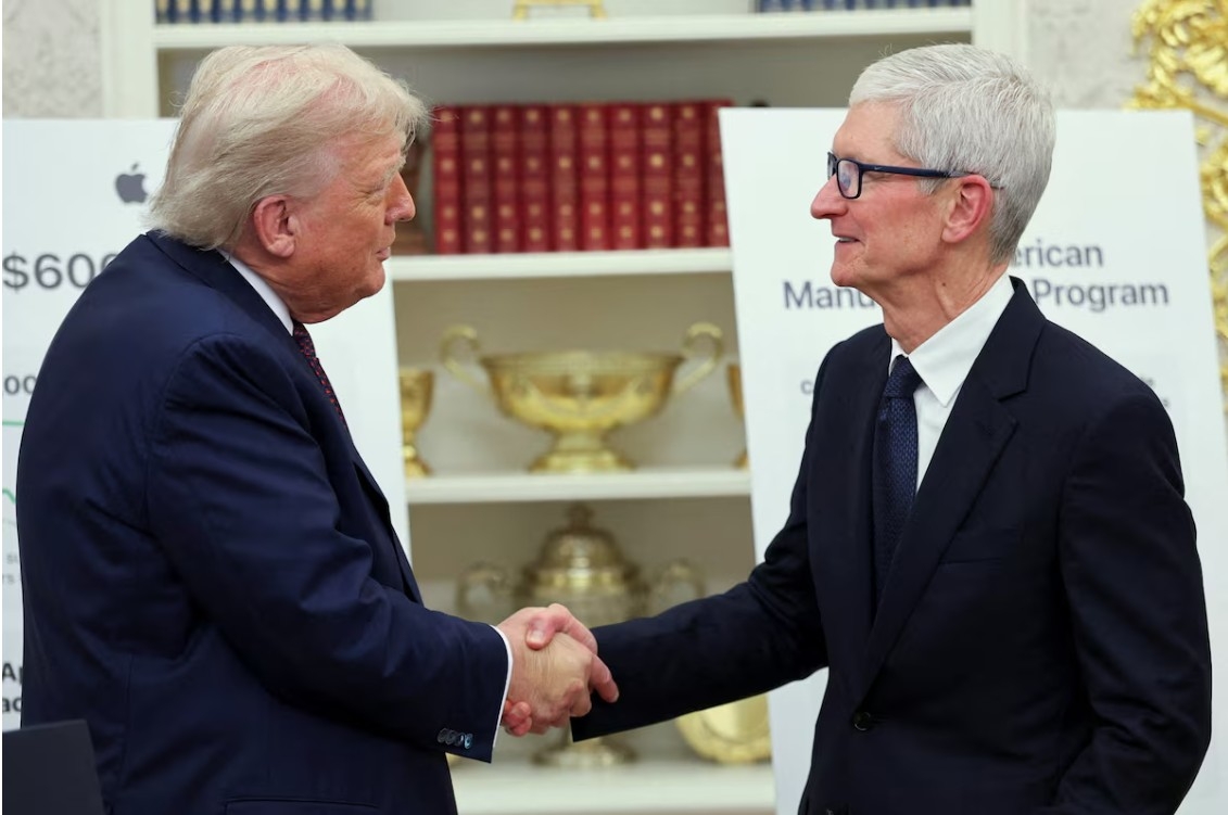 Tổng thống Hoa Kỳ Donald Trump và Giám đốc điều hành Apple Tim Cook bắt tay nhau khi Apple thông báo về khoản đầu tư 100 tỷ đô la vào ngành sản xuất của Hoa Kỳ, tại Phòng Bầu dục ở Nhà Trắng ở Washington, DC, Hoa Kỳ, ngày 6 tháng 8 năm 2025.