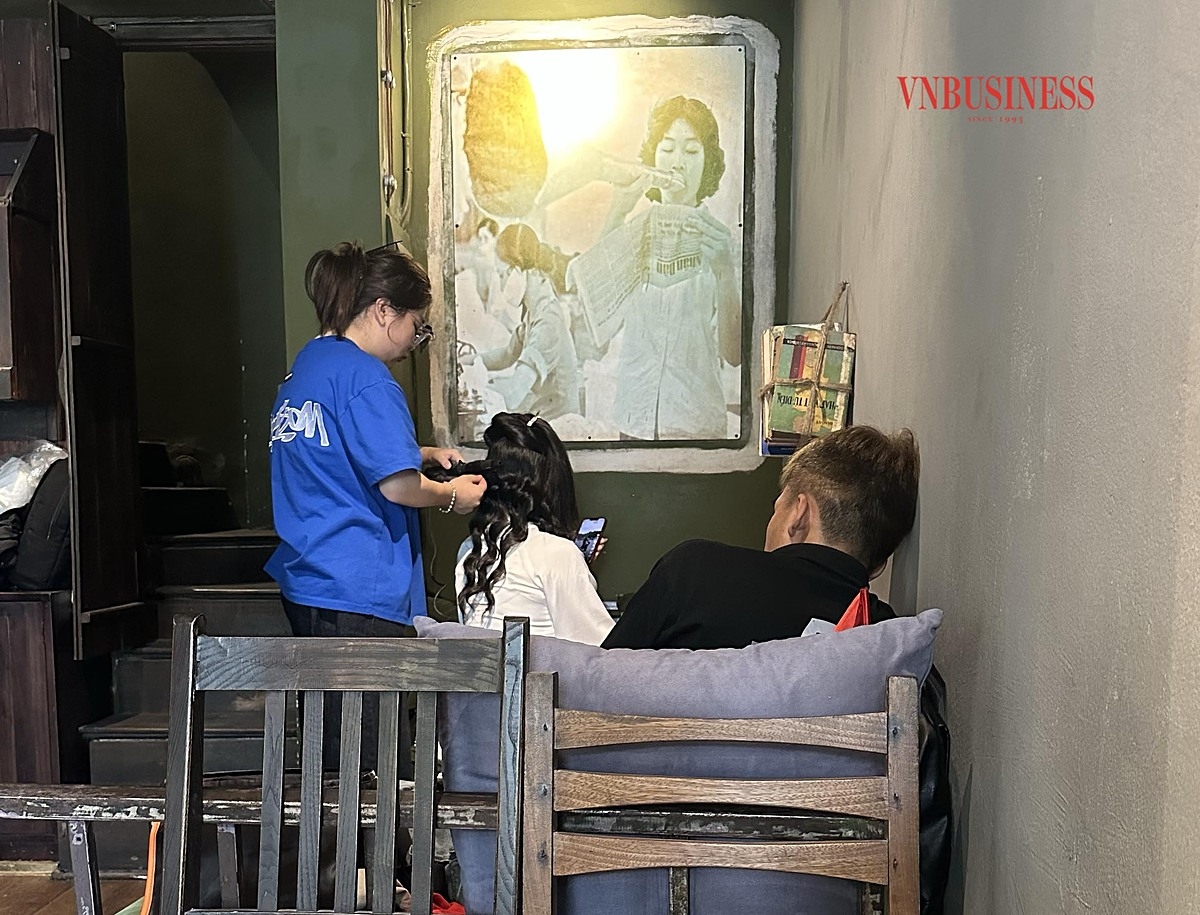 Thợ trang điểm, làm tóc cho khách trong quán cà phê trên đường Điện Biên Phủ.