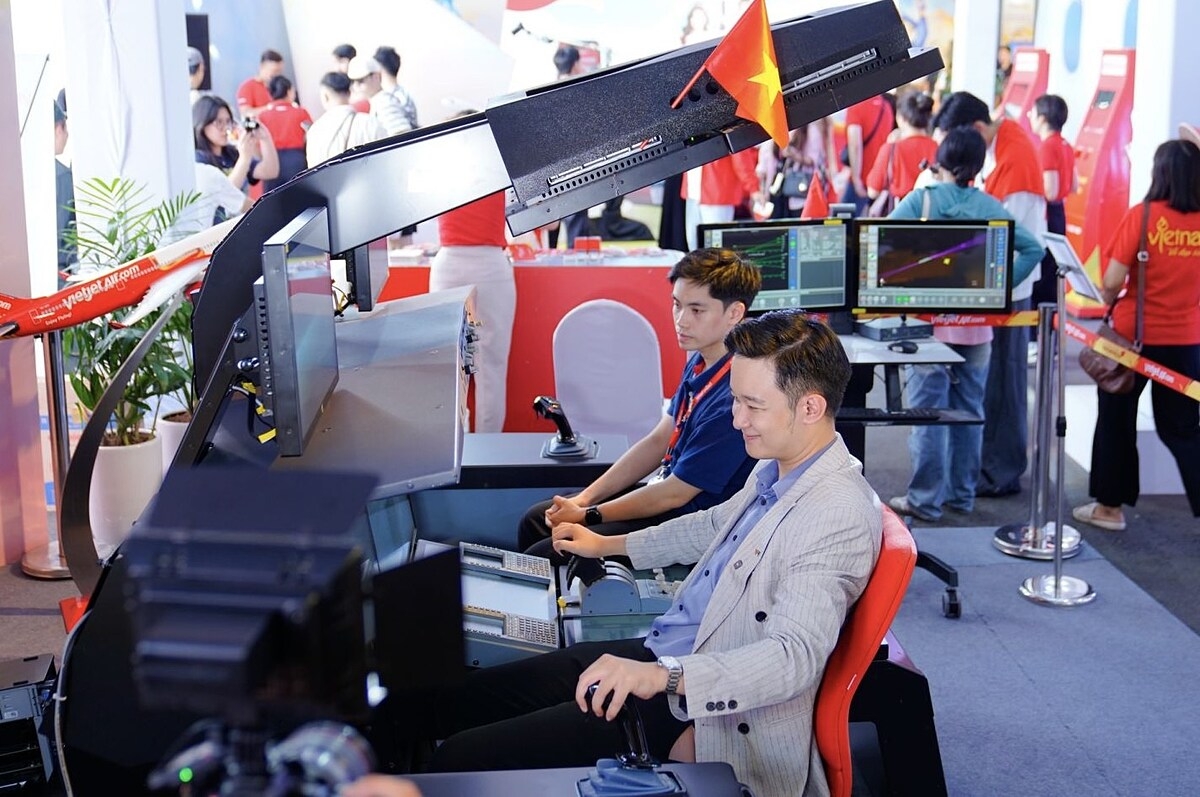 Khách thăm quan trải nghiệm buồng lái mô phỏng huấn luyện phi công tại Triển lãm.