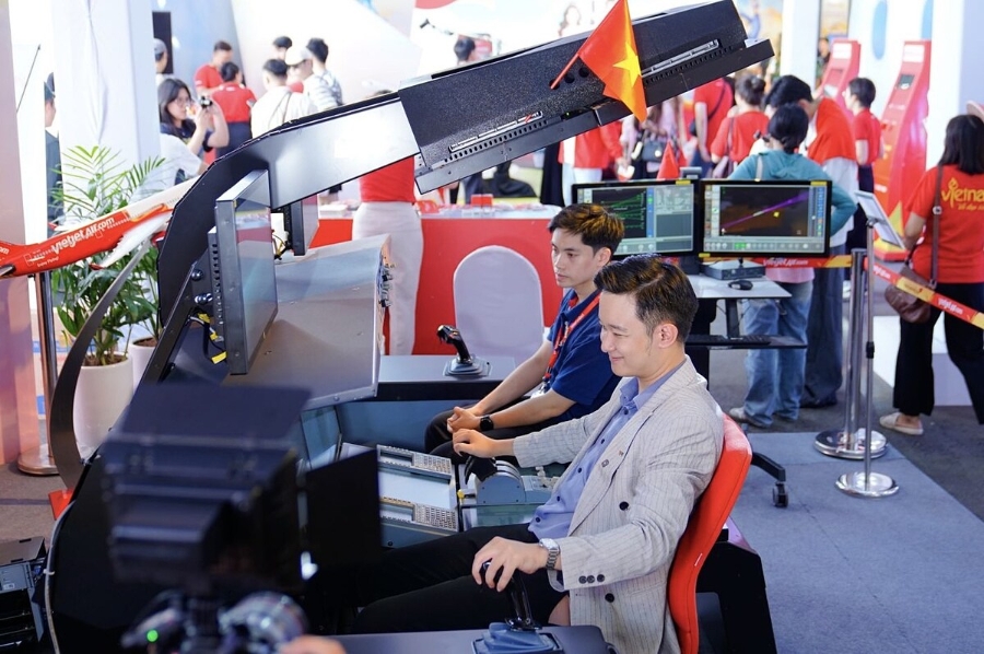 Khách thăm quan trải nghiệm buồng lái mô phỏng huấn luyện phi công tại Triển lãm.