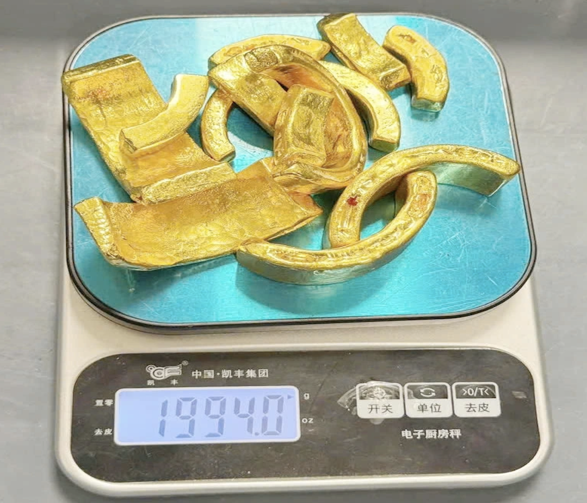 12 miếng kim loại màu vàng &lpar;nghi là vàng&rpar; nặng gần 2 kg được giấu trong ống kính máy ảnh để trong vali của hành khách được lực lượng chức năng phát hiện ngày 25/6 tại sân bay Quốc tế Nội Bài.