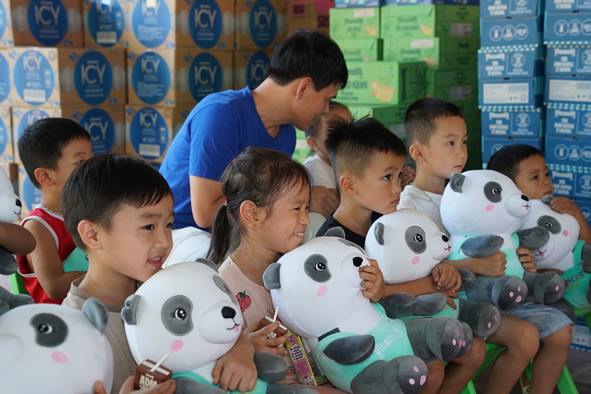 Nỗi sợ những ngày lũ dâng chưa tan, nhưng nụ cười đã hé lại khi các em được các cô chú Vinamilk đến tặng sữa, tặng quà. Ảnh: Tịnh Không