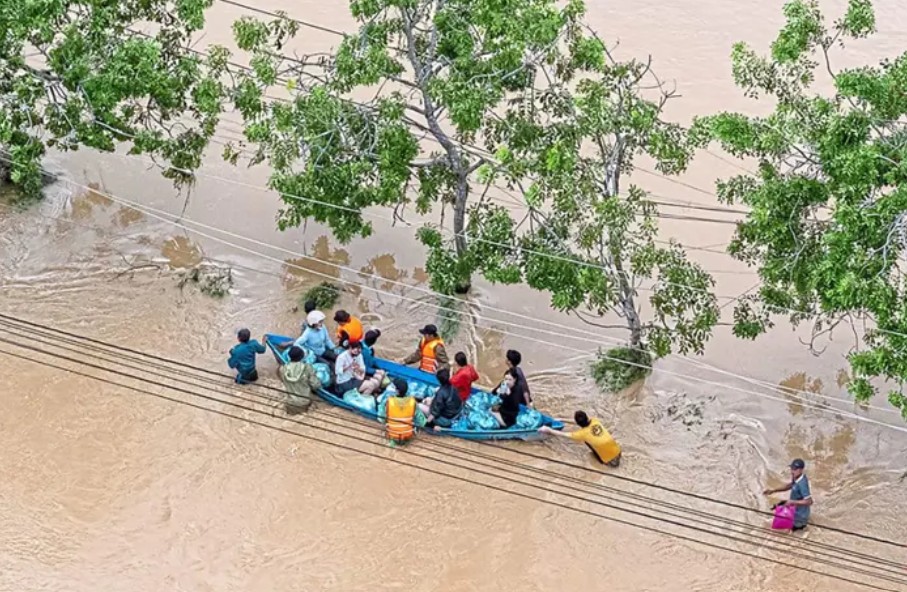 Người dân lội qua dòng nước lũ ở Phan Rang, tỉnh Khánh Hòa.