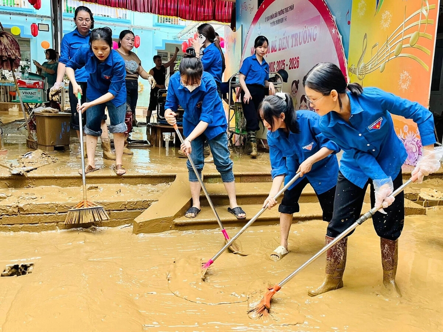 Thanh niên Việt Nam hỗ trợ người dân dọn dẹp sau lũ.