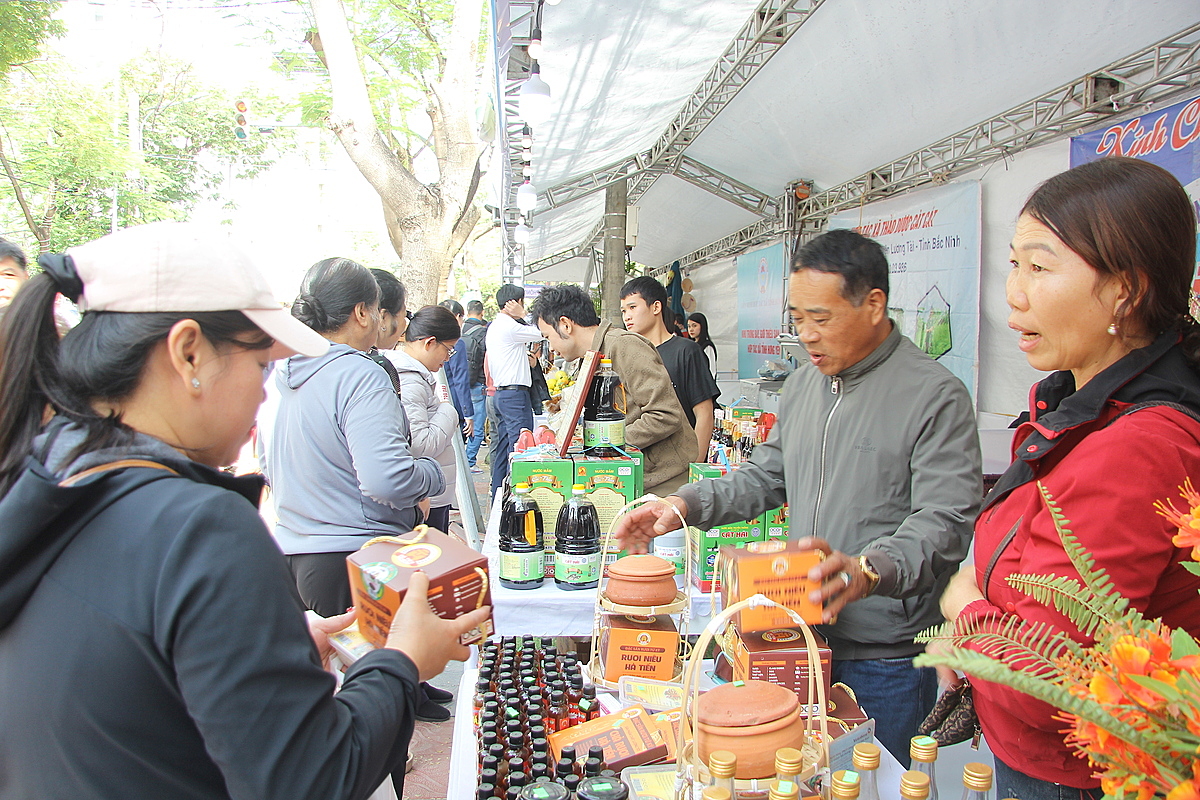 Ông Bẩy &lpar;người mặc áo khoác xám&rpar; đang giới thiệu sản phẩm rươi tới khách hàng.