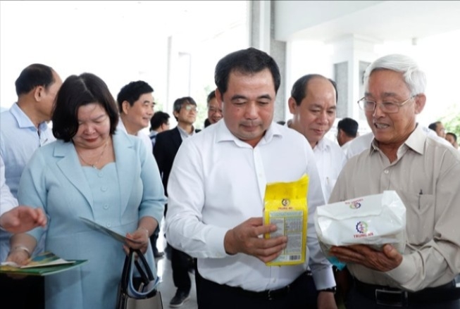 Bộ trưởng Trần Đức Thắng và Chủ tịch Liên minh HTX Việt Nam Cao Xuân Thu Vân nghe ông Phạm Thái Bình - Chủ tịch HĐQT Công ty Cổ phần Nông nghiệp Công nghệ cao Trung An giới thiệu sản phẩm tại hội nghị sáng ngày 8/3.