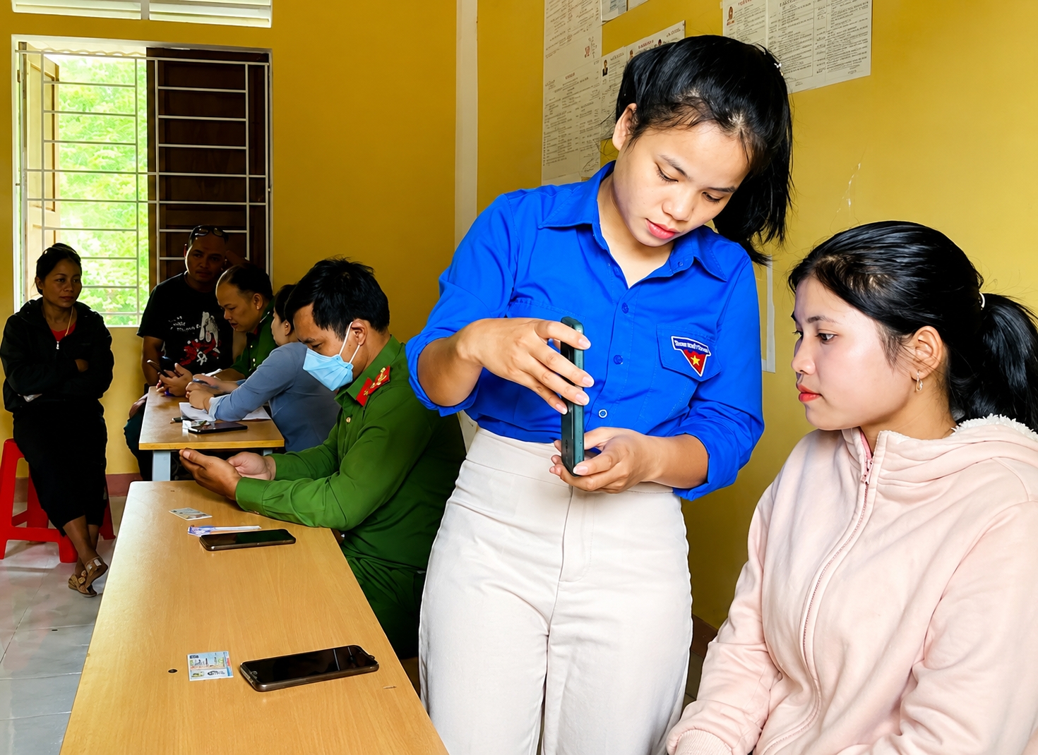 Thành viên tổ công nghệ cộng đồng hướng dẫn người dân sử dụng các dịch vụ công trên điện thoại.
