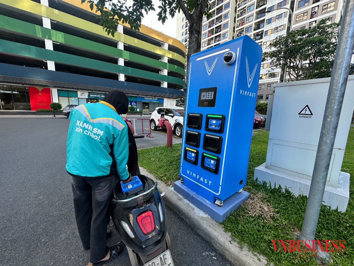 Tài xế xe công nghệ đang đổi thay pin xe điện tại một trạm đổi pin ở Hà Nội.