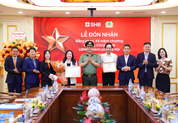 Đại tá Nguyễn Tiến Đạt, Phó Giám đốc Công an TP Hà Nội trao bằng khen và công nhận tới đại diện lãnh đạo SHB.