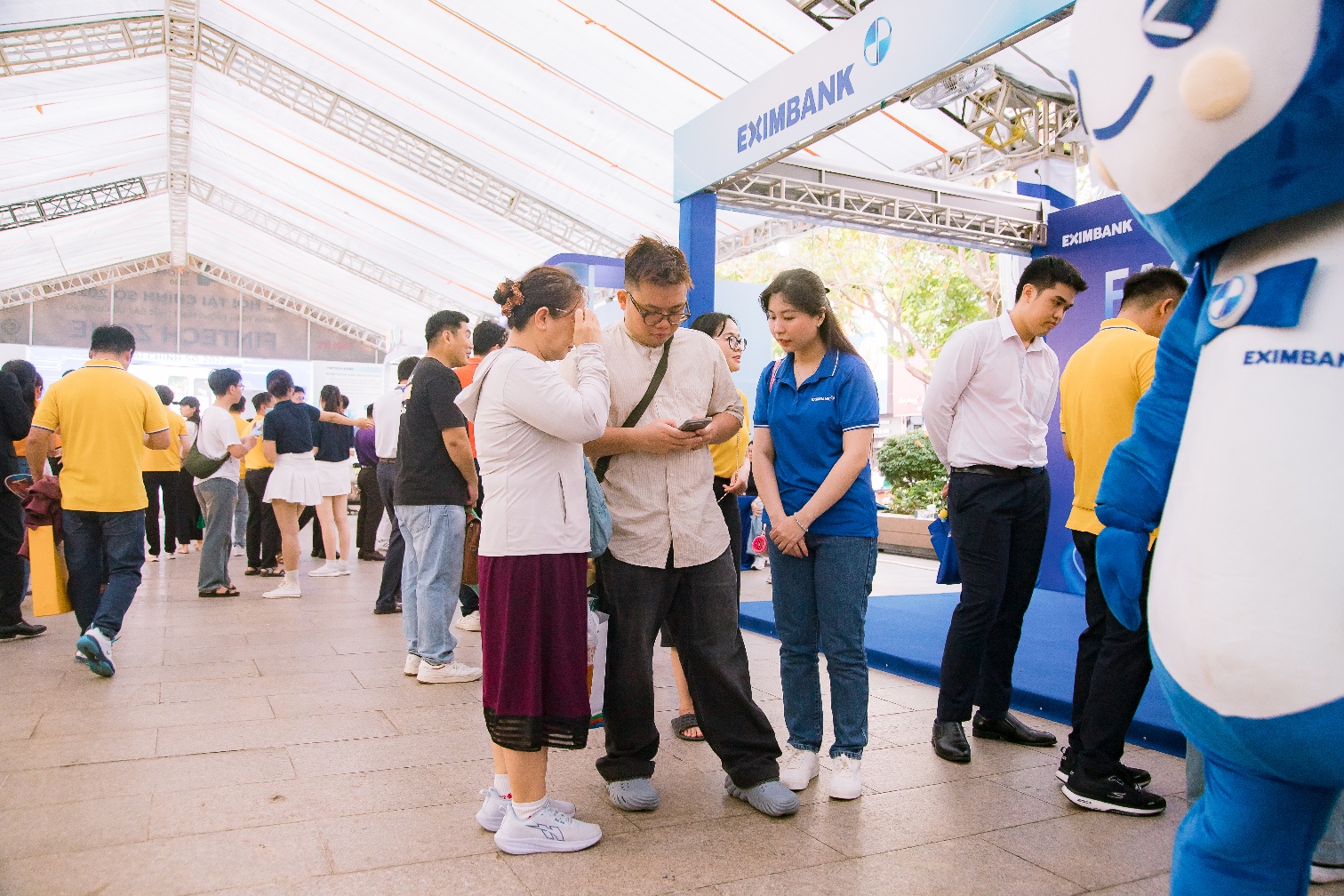 Khách tham quan tìm hiểu và trải nghiệm dịch vụ ngay tại gian hàng với sự hướng dẫn trực tiếp từ đội ngũ Eximbank.