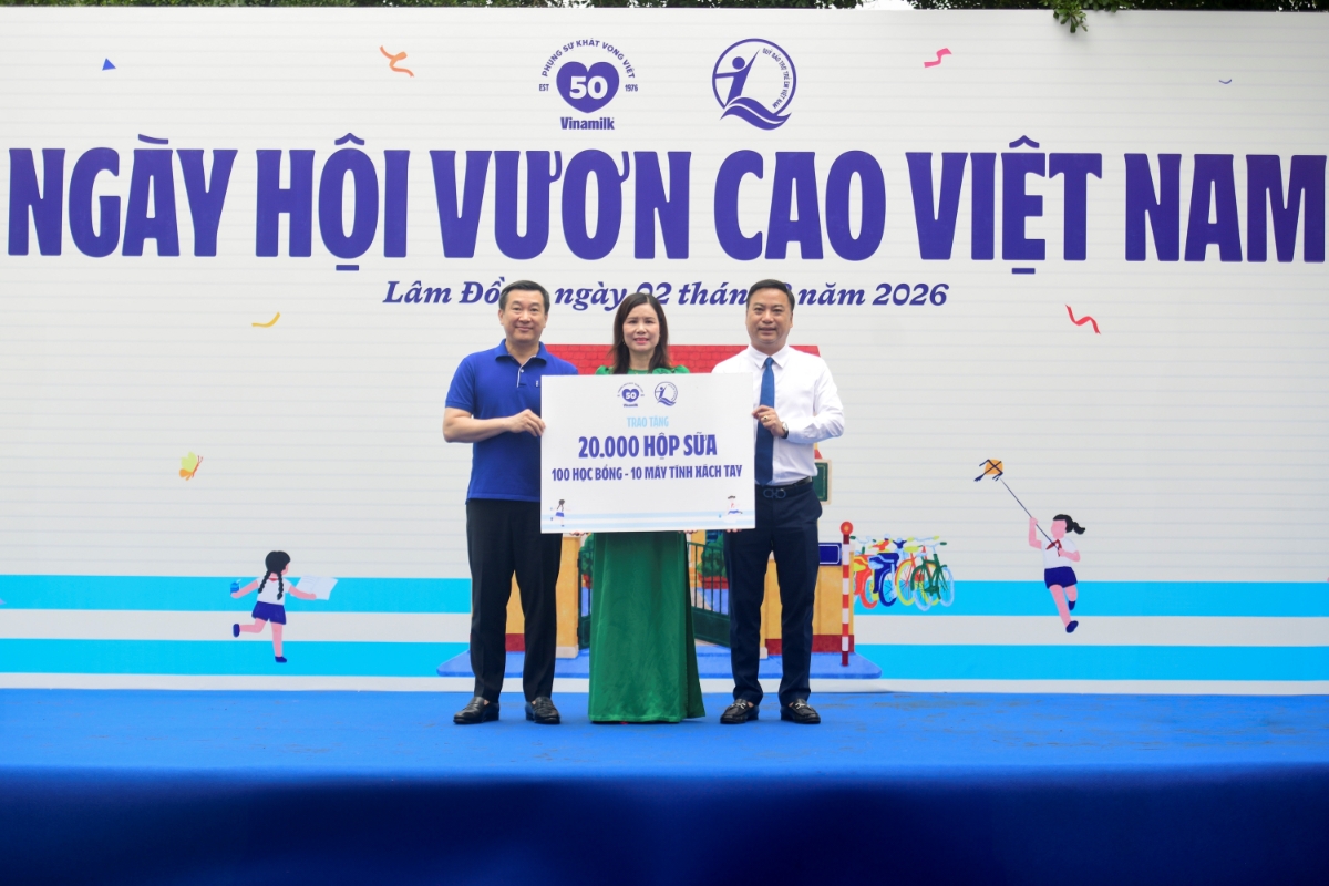 Đại diện Quỹ sữa Vươn cao Việt Nam, ông Đỗ Thanh Tuấn - Giám đốc Đối ngoại Vinamilk (bên trái) và ông Đinh Tiến Hải - Giám đốc Quỹ Bảo trợ Trẻ em Việt Nam - trao bảng tượng trưng các phần quà thiết thực cho đại diện Trường Tiểu học An Hiệp, xã Hiệp Thạnh (Ảnh: Hải An).